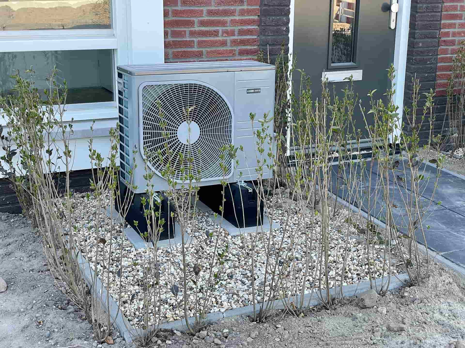 unité extérieure de pompe à chaleur air-eau posée devant une maison
